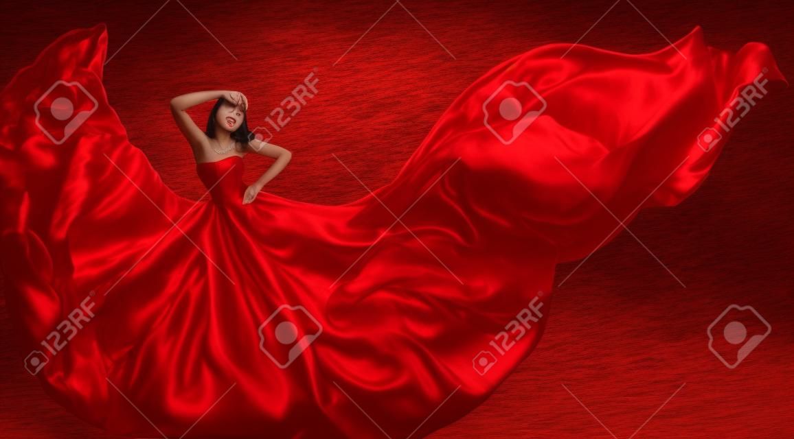 女性赤ドレスのシルク生地を飛んで、暴風で模範の踊りをファッション
