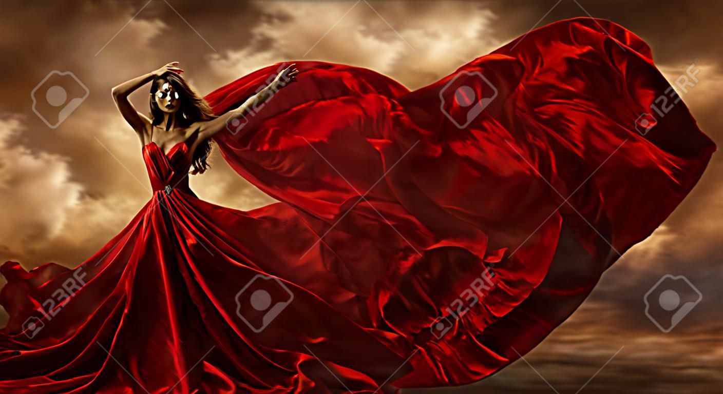 Vrouw rode jurk vliegende zijde stof, mode model dans in storm wind