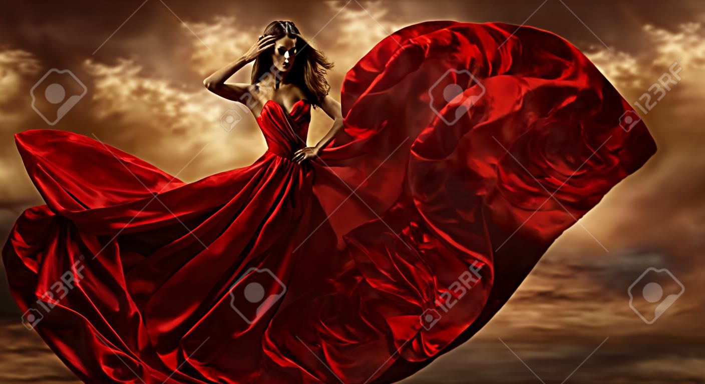 女性赤ドレスのシルク生地を飛んで、暴風で模範の踊りをファッション