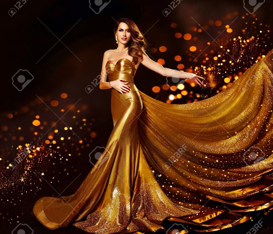 Moda mulher vestido de ouro, menina de luxo em elegante vestido de tecido dourado, voando Sparkles pano