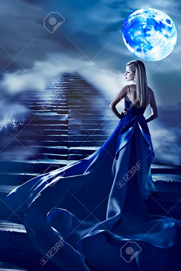 Mujer sube escaleras a Fantasy Moon Heaven, chica de hadas con vestido azul noche, vista posterior modelo mirando por encima del hombro