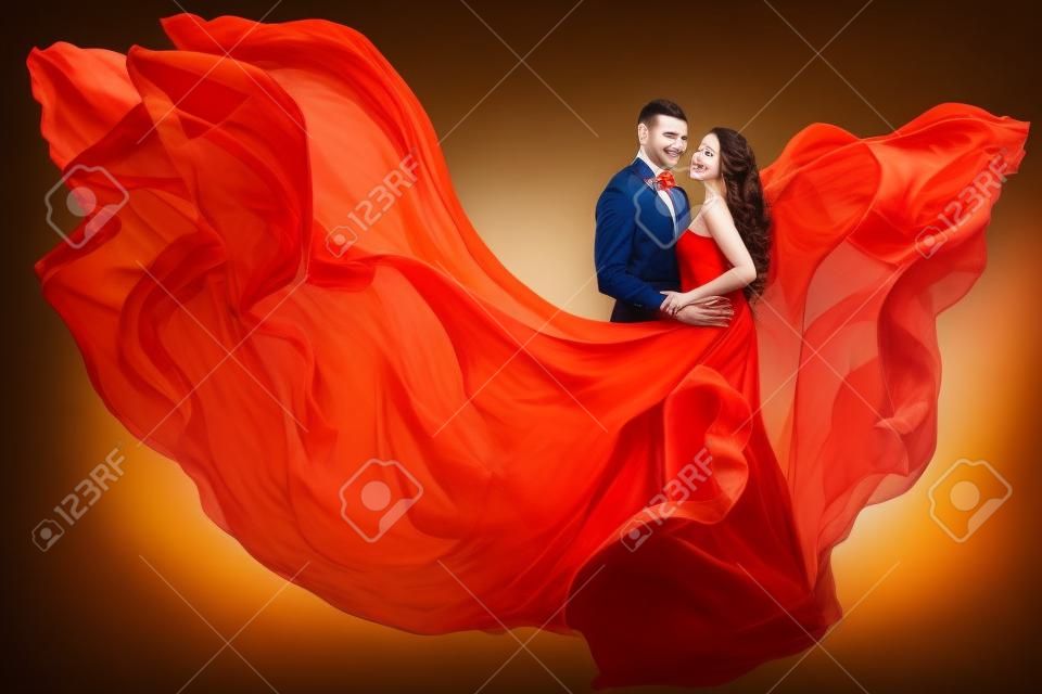 Retrato da beleza do casal, namorando o homem e a mulher de sonho no vestido de vôo de acenar como a chama no vento