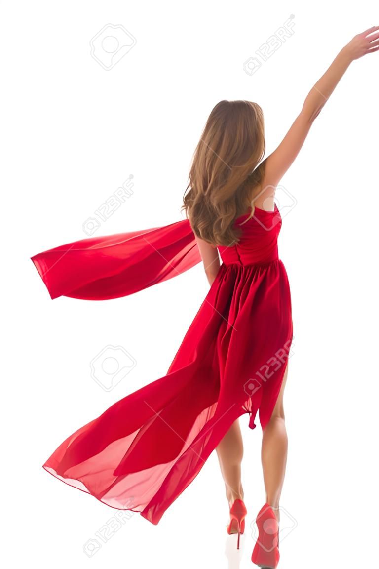 Femme dos vue arrière marchant en robe rouge flottant au vent, fille en soufflant en agitant des vêtements sur blanc
