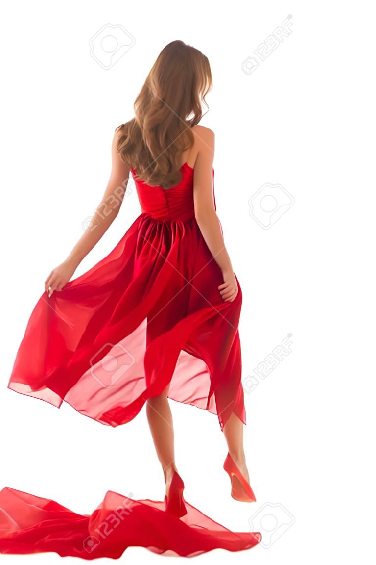 Femme dos vue arrière marchant en robe rouge flottant au vent, fille en soufflant en agitant des vêtements sur blanc