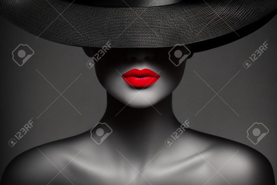 Red lips make-up close-up. mysterieuze mode vrouw gezicht verborgen door zwart geborduurde hoed. elegante retro lady fine art portret over grijze achtergrond