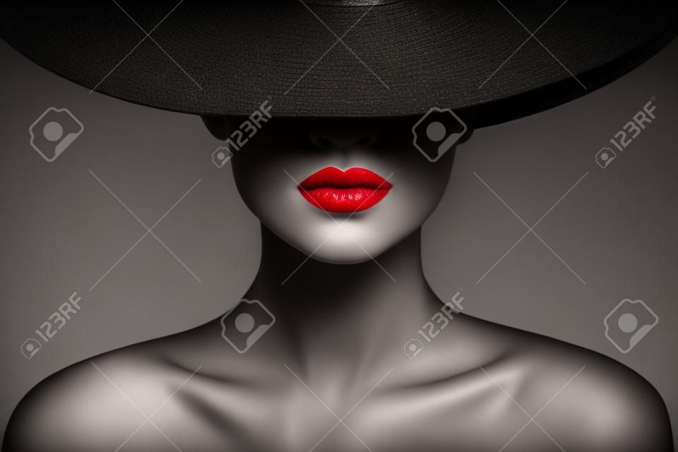 Red lips make-up close-up. mysterieuze mode vrouw gezicht verborgen door zwart geborduurde hoed. elegante retro lady fine art portret over grijze achtergrond