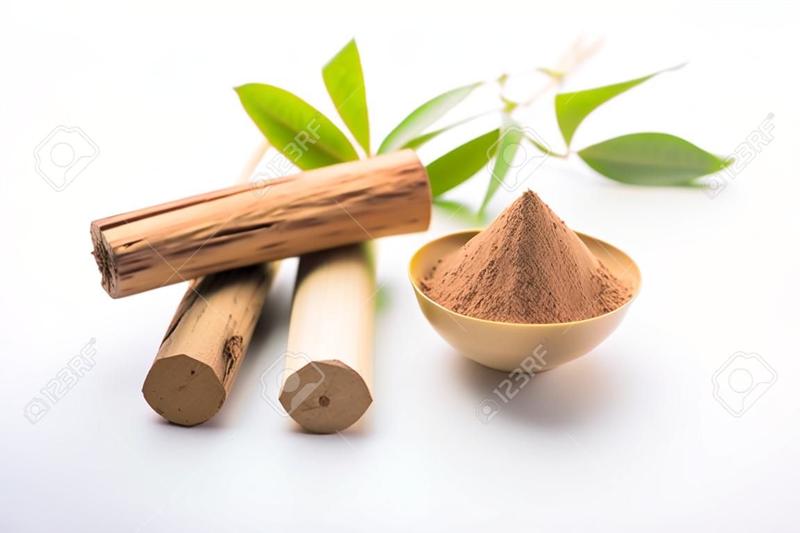 Chandan or sandalwood powder with sticks and green leaves
