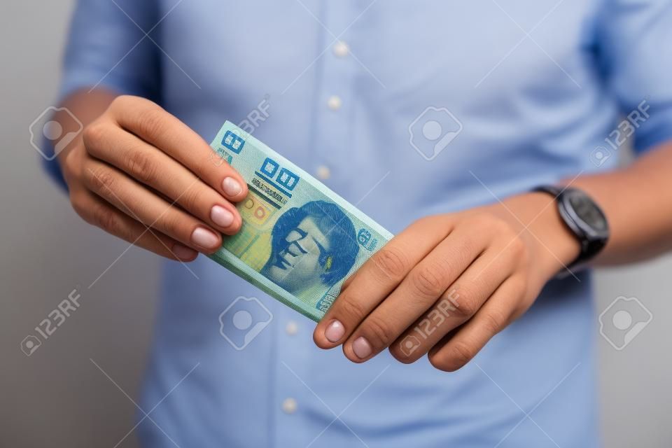 Un joven rico con una camisa azul informal que tiene mucho dinero polaco