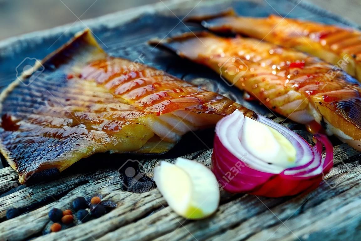 Sea fish cooked on the barbecue. Sea fish fillet baked on the grill. The concept of folk cuisine, restaurant, cooking.