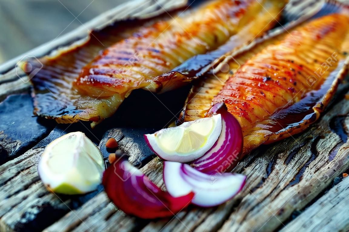 Sea fish cooked on the barbecue. Sea fish fillet baked on the grill. The concept of folk cuisine, restaurant, cooking.