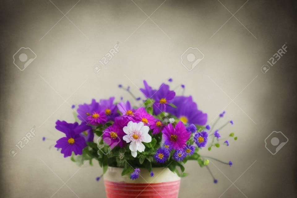 Bellissimi fiori estivi in un vaso vintage su sfondo bianco. Messa a fuoco selettiva. Posto per il testo.