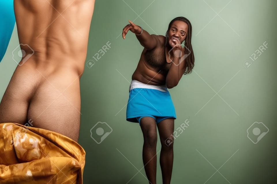 uomo imbarazzato con i pantaloni giù, mentre la donna si prende gioco della sua virilità