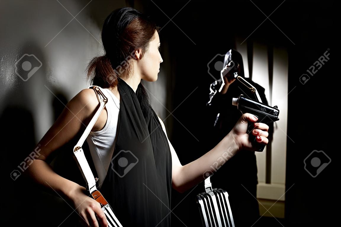 женщина, используя баллончики для самообороны против грабителя в темном переулке