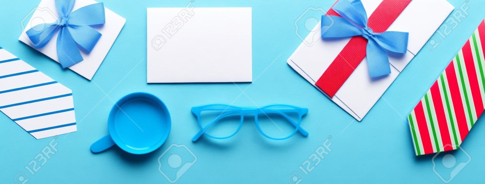 Father's Day gift. Top view design concept of holiday idea with greeting card on blue table background.