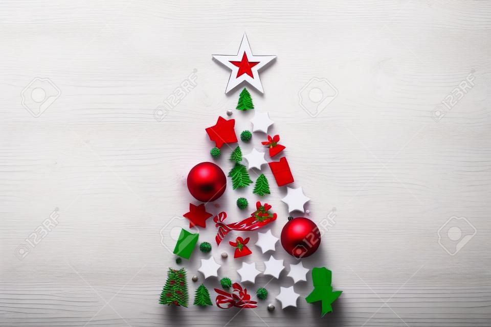 Kerstboom achtergrond concept gedecoreerd van wit houten speelgoed decoraties geïsoleerd op rode tafel plat leggen, vrolijke xmas winter minimale feestelijke viering compositie, bovenaanzicht, kopieer ruimte
