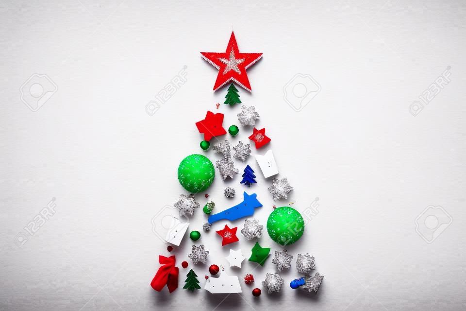 Kerstboom achtergrond concept gedecoreerd van wit houten speelgoed decoraties geïsoleerd op rode tafel plat leggen, vrolijke xmas winter minimale feestelijke viering compositie, bovenaanzicht, kopieer ruimte