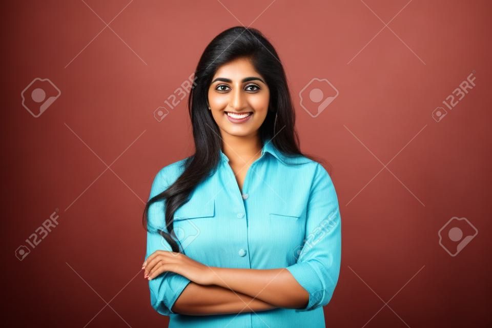 Zuversichtlich lächelnde indische Geschäftsfrau blickt isoliert auf den Hintergrund in die Kamera.
