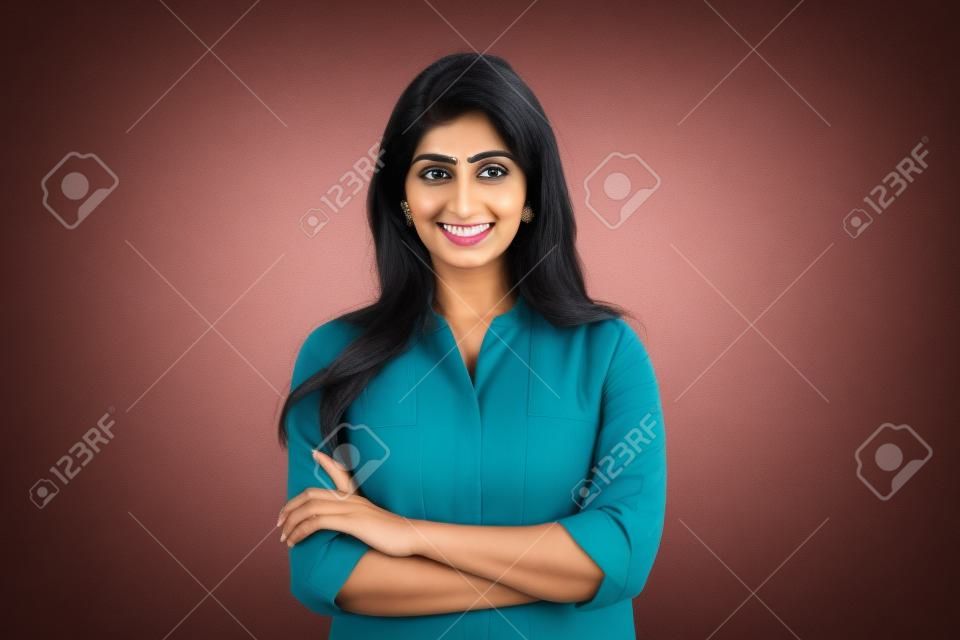 Zuversichtlich lächelnde indische Geschäftsfrau blickt isoliert auf den Hintergrund in die Kamera.