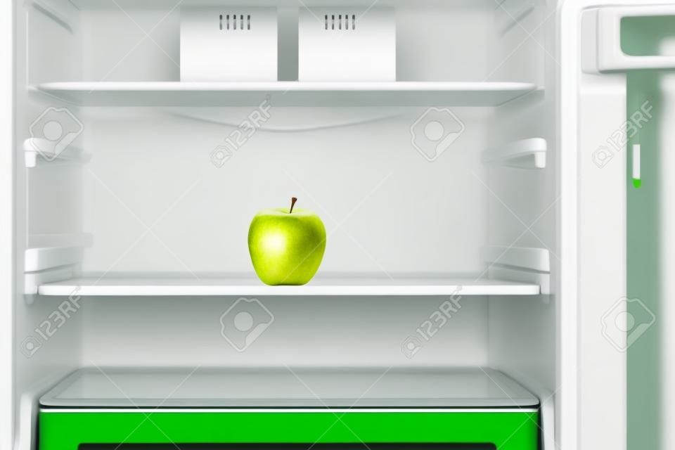 Pomme verte sur l'étagère du réfrigérateur vide ouvert. Concept de régime de perte de poids.