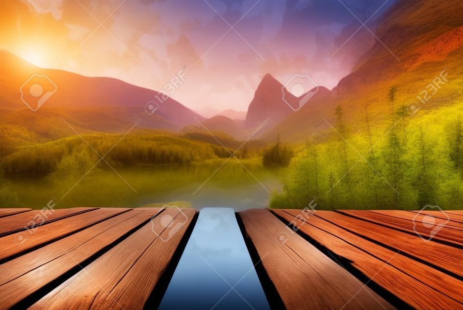 Fast mountain river flowing In sunset time with empty wooden batten bridge. Natural template landscape.