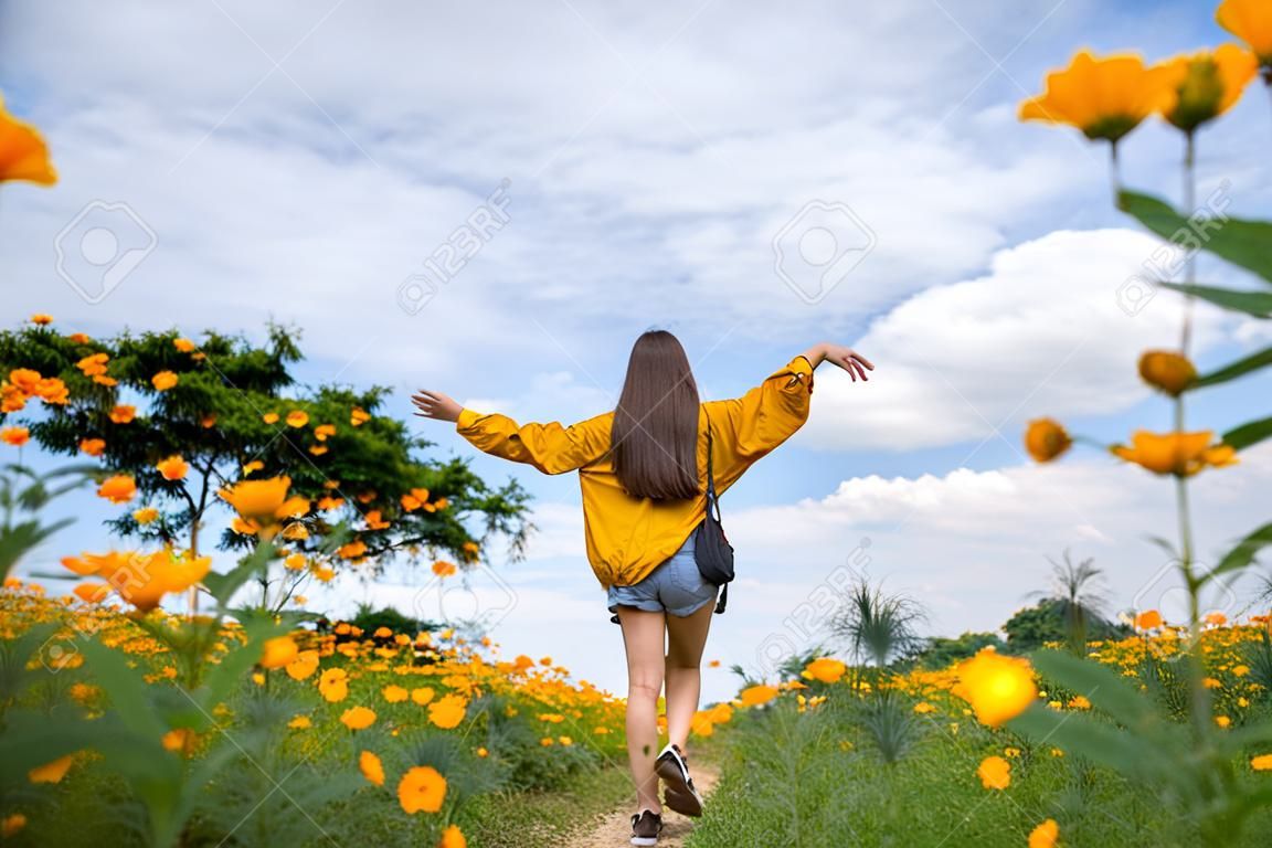 Asian woman tourist relax and walk in yellow flower fields.