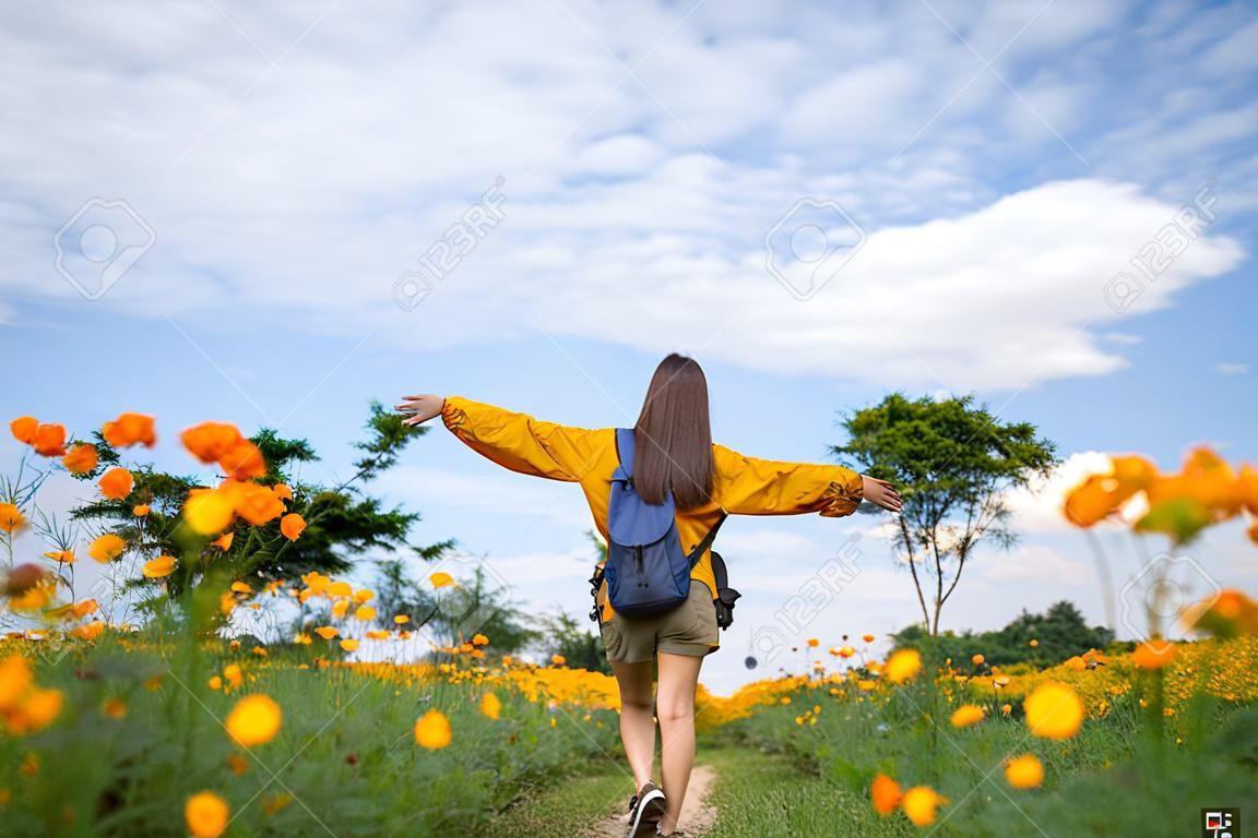Asian woman tourist relax and walk in yellow flower fields.