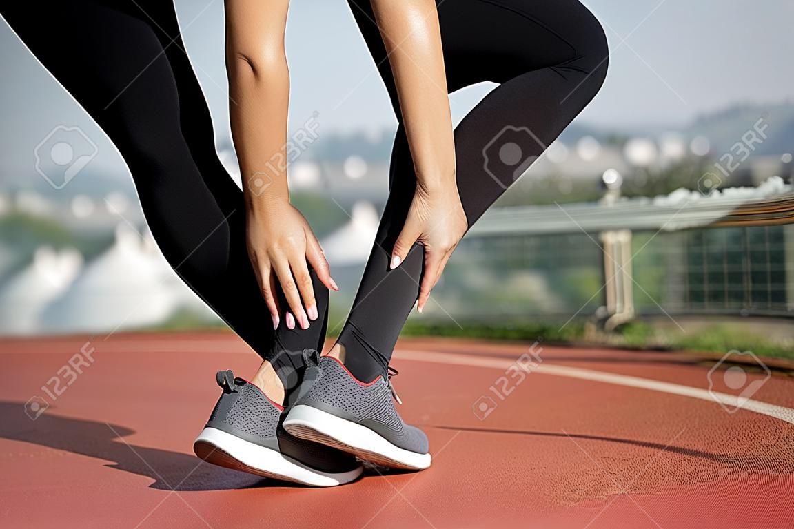 Mulher asiática com dor na perna após o exercício ao ar livre da manhã