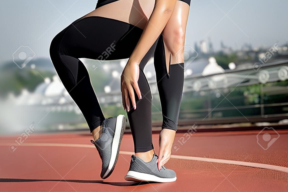 Mulher asiática com dor na perna após o exercício ao ar livre da manhã