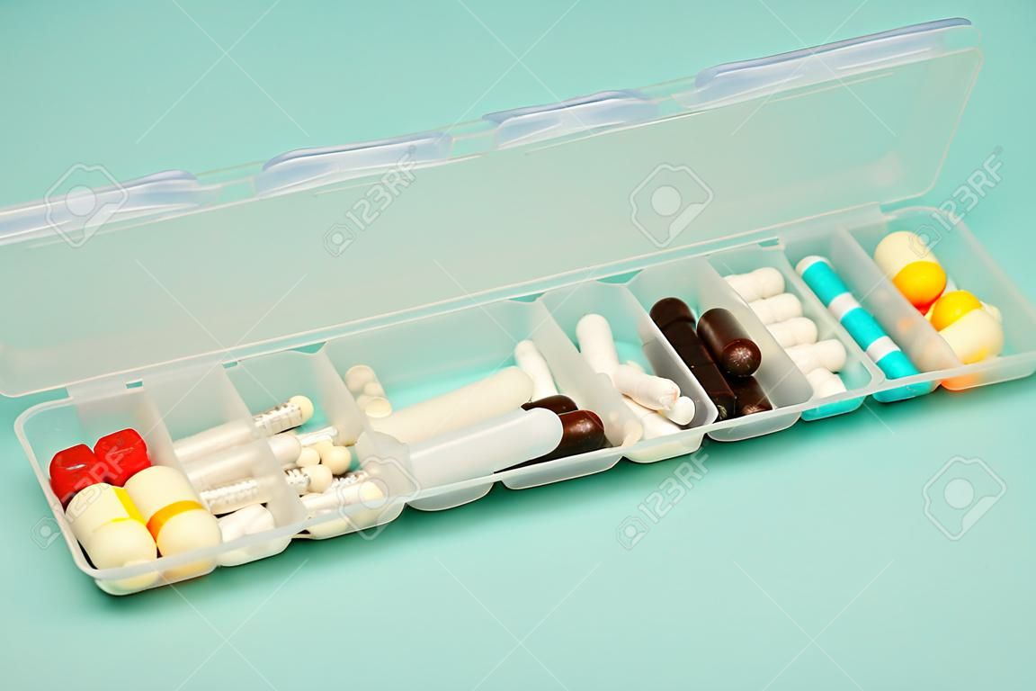 Assorted medical drugs and syringe on blue background, with copy space