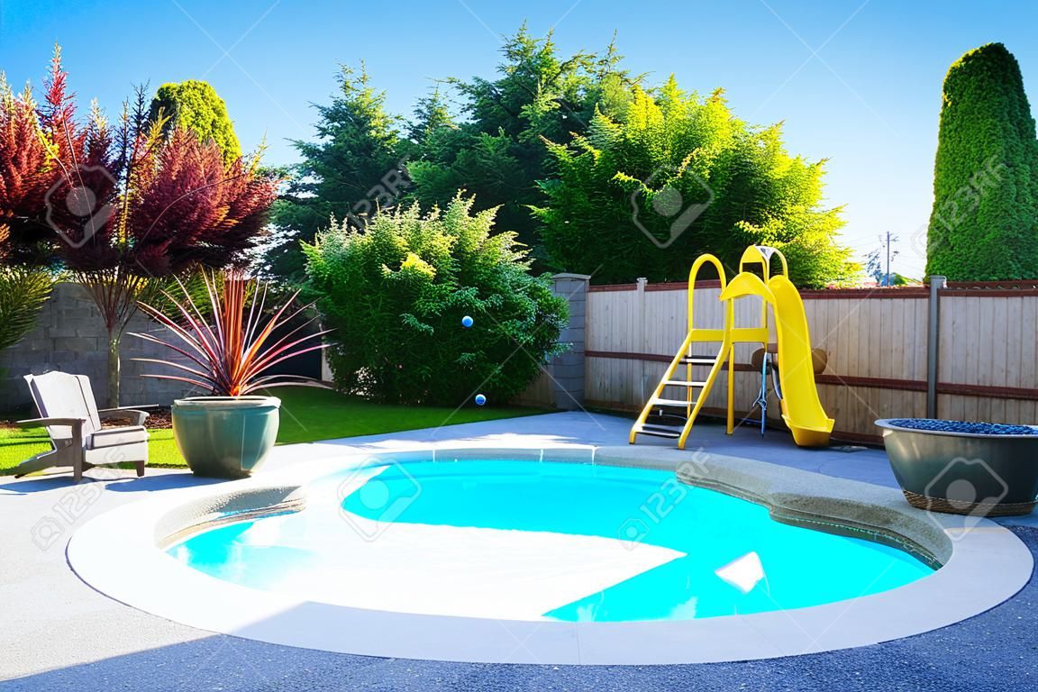 Fenced backyard with small beautiful swimming pool and playground