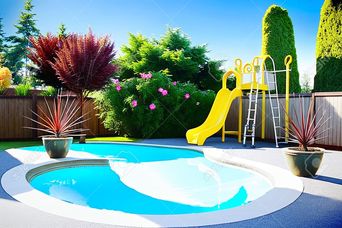 Fenced backyard with small beautiful swimming pool and playground
