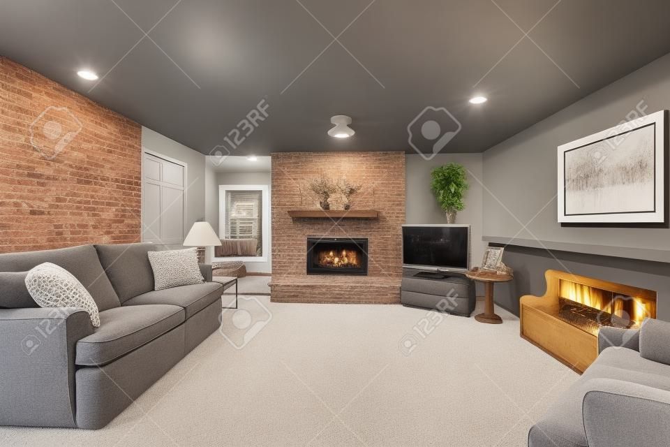 Cozy American living room with gray sofa, carpet floor and brick fireplace.