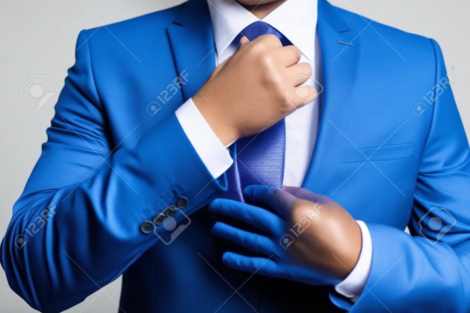 Hombre de negocios en traje azul atar la corbata