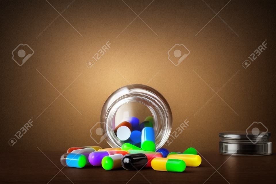 Garrafa de comprimidos do vidro marrom e cápsulas coloridas
