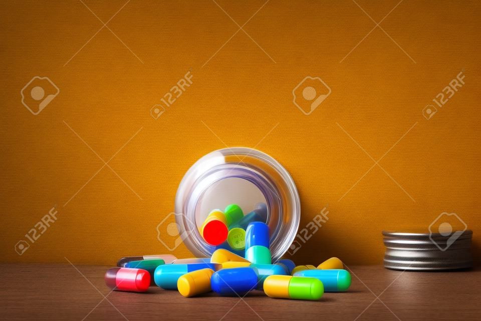 Bouteille de pilules du verre brun et des capsules colorées