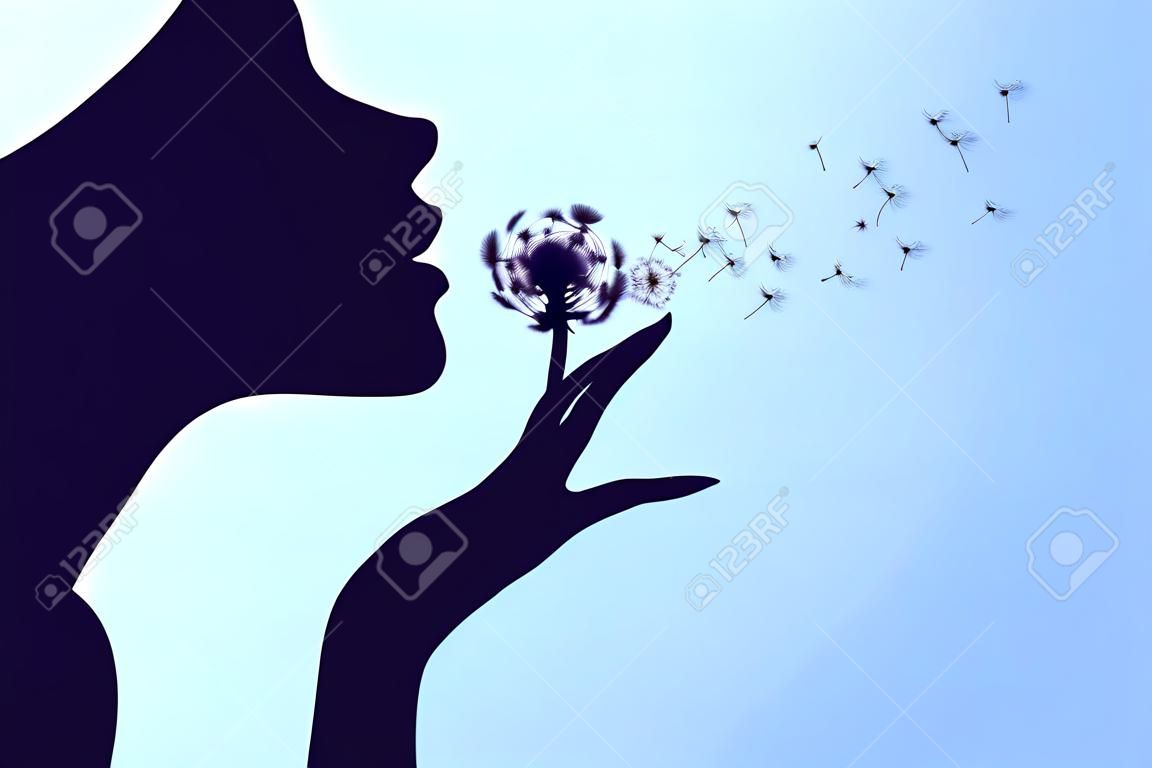 Silhouette of a woman blowing the dandelion