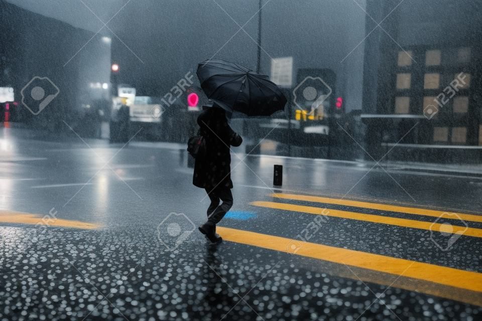 pedestre com um guarda-chuva nos dias chuvosos na cidade de Bilbao, país do basque, espanha