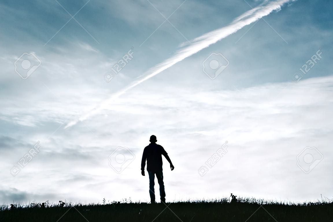 La silhouette dell'uomo si sente libera tra le nuvole in montagna