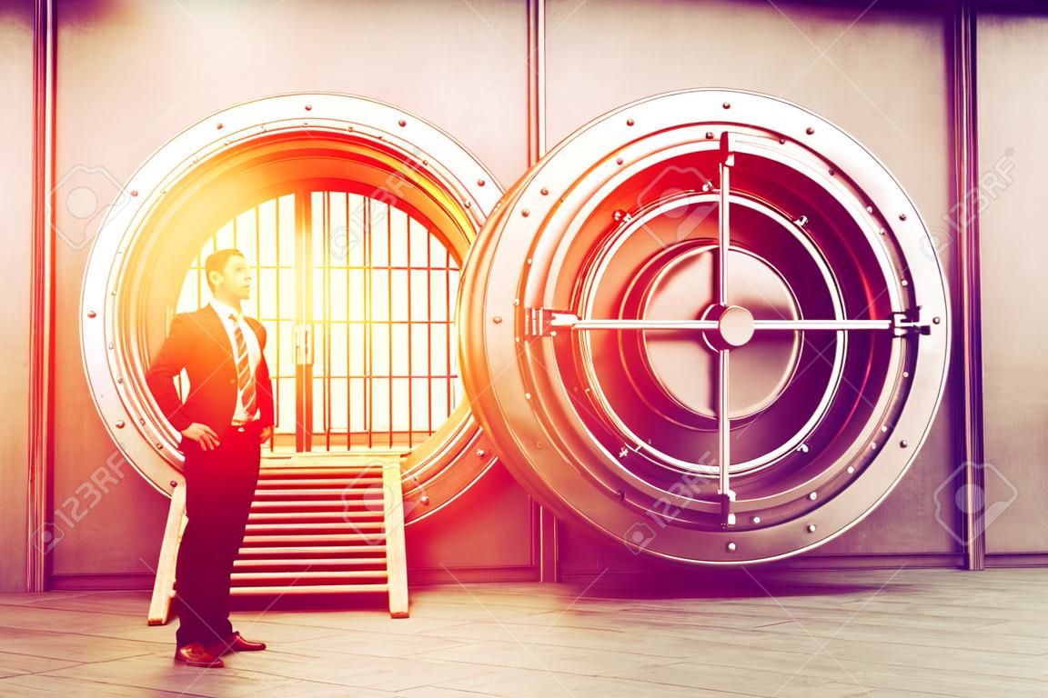 Confident businessman is standing near wide open vault door. Concept of money saving. 3d rendering. Toned image