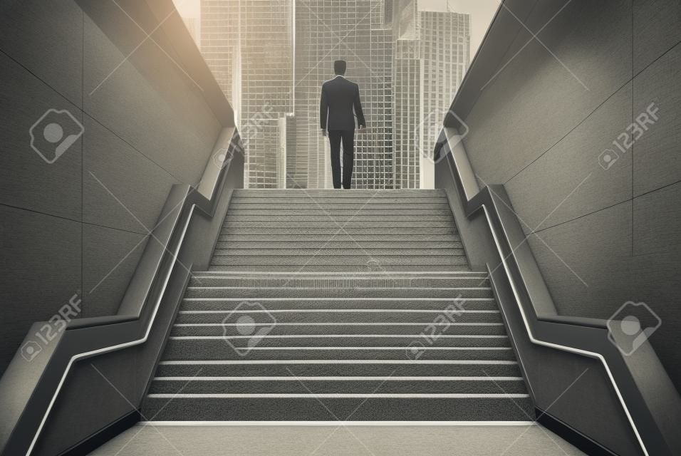 Rear view of a businessman climbing stairs to get to a large city center. Concept of success and appreciation. Toned image