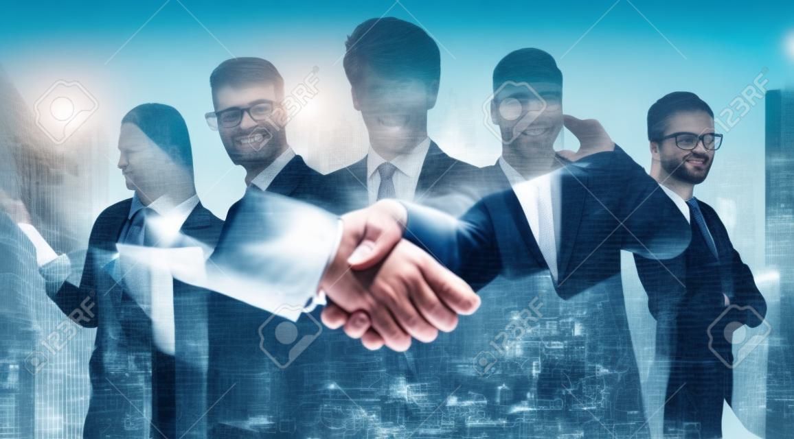 Close up of two businessmen shaking hands with double exposure of business people in abstract city. Business deal and partnership concept. Toned image