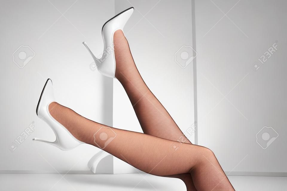 Image de jambes féminines portant des bas blancs et des talons hauts - image