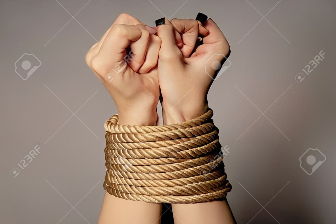 Les mains de la femme attachées avec une corde