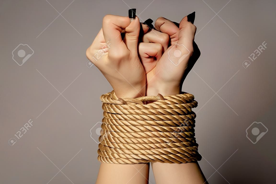 Woman's hands tied with rope