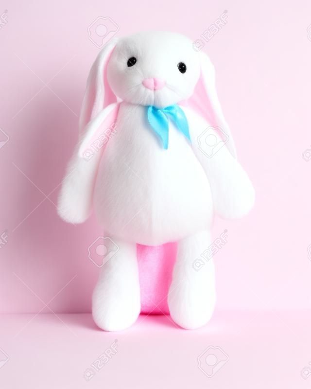Różowy królik lalka z dużymi uszami na białym tle. Urocze wypchane zwierzę i puszyste futerko dla dzieci.