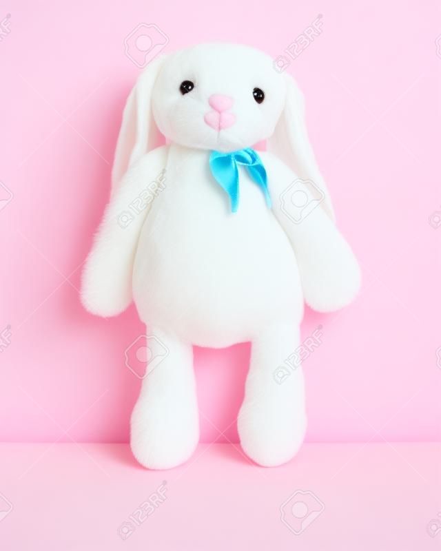 Poupée lapin rose avec de grandes oreilles isolées sur fond blanc. Peluche mignonne et fourrure duveteuse pour les enfants.