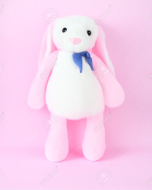 Bambola di coniglio rosa con grandi orecchie isolate su sfondo bianco. Simpatico peluche e soffice pelliccia per bambini.