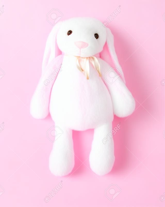 Bambola di coniglio rosa con grandi orecchie isolate su sfondo bianco. Simpatico peluche e soffice pelliccia per bambini.