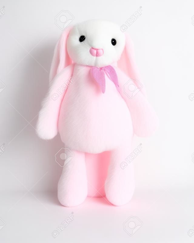 Poupée lapin rose avec de grandes oreilles isolées sur fond blanc. Peluche mignonne et fourrure duveteuse pour les enfants.