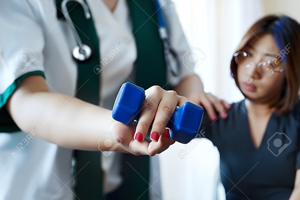 Woman doing the Rehabilitation therapy pain in clinic. Doctor or Physiotherapist. Doctor or Physiotherapist examining treating injured arm and shoulder.